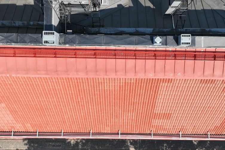 Experium drone-kattotarkastus ilmakuva punakattoisesta rakennuksesta, katon kunnon dokumentointi ja visuaalinen tarkastus.